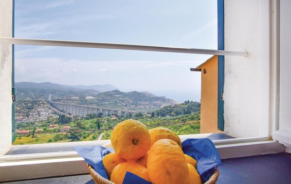 A window with a view of a bridge and a basket of oranges on the windowsill. - Gorgeous home in Imperia, Loc. Poggi (Imperia, Loc. Poggi)