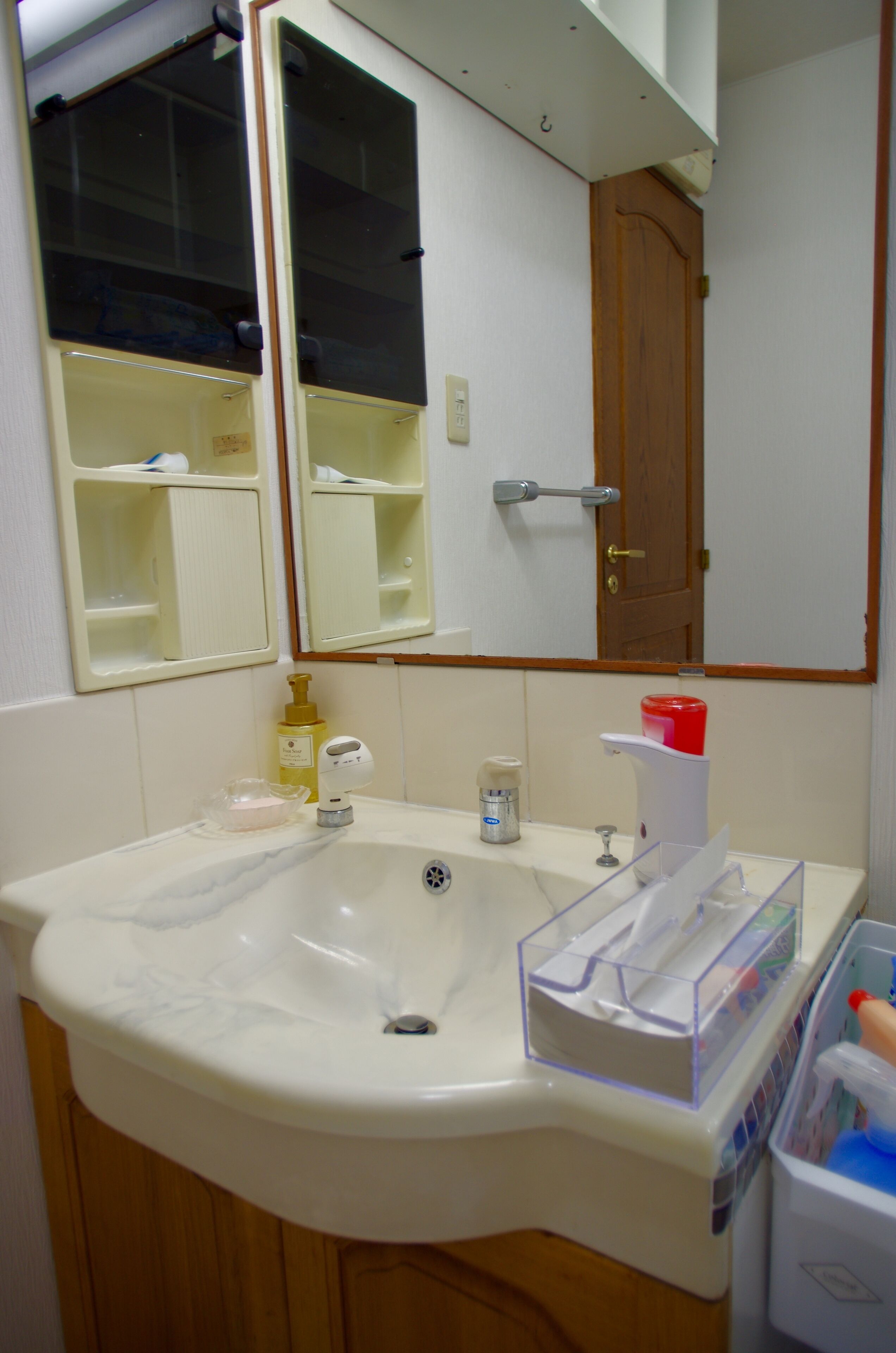A bathroom with a sink, mirror, and storage cabinet.