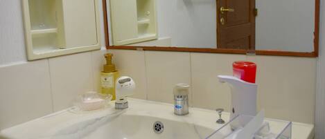 A bathroom with a sink, mirror, and storage cabinet.