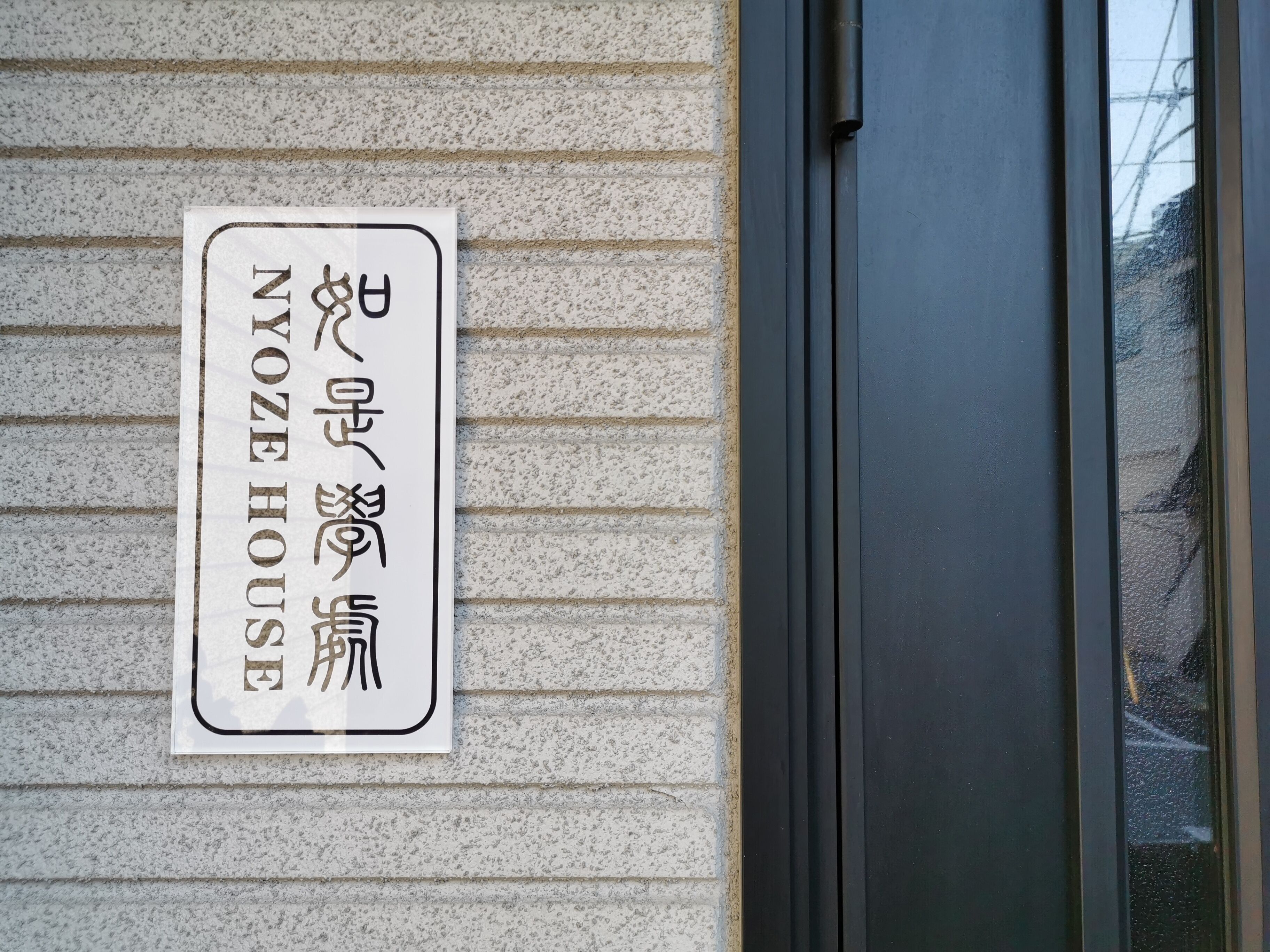 Une enseigne avec des caractères japonais sur le mur d’un immeuble.