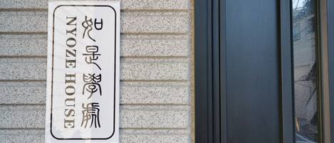 Une enseigne avec des caractères japonais sur le mur d’un immeuble.