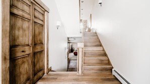 Un pasillo estrecho con una escalera de madera que conduce a una plataforma.