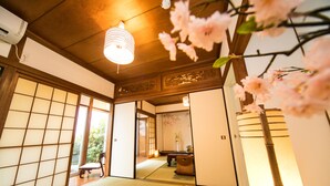 Um quarto japonês tradicional com tatames, portas deslizantes e teto de madeira baixo.