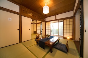 A traditional Japanese room with tatami flooring, a low wooden table, and sliding doors.
