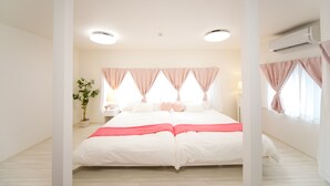 Quarto com cama, cortinas, um vaso de planta e ar condicionado.