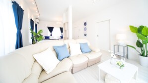 Ein modernes Wohnzimmer mit einem beigefarbenen Sofa, einem weißen Couchtisch und einer Chandelier.