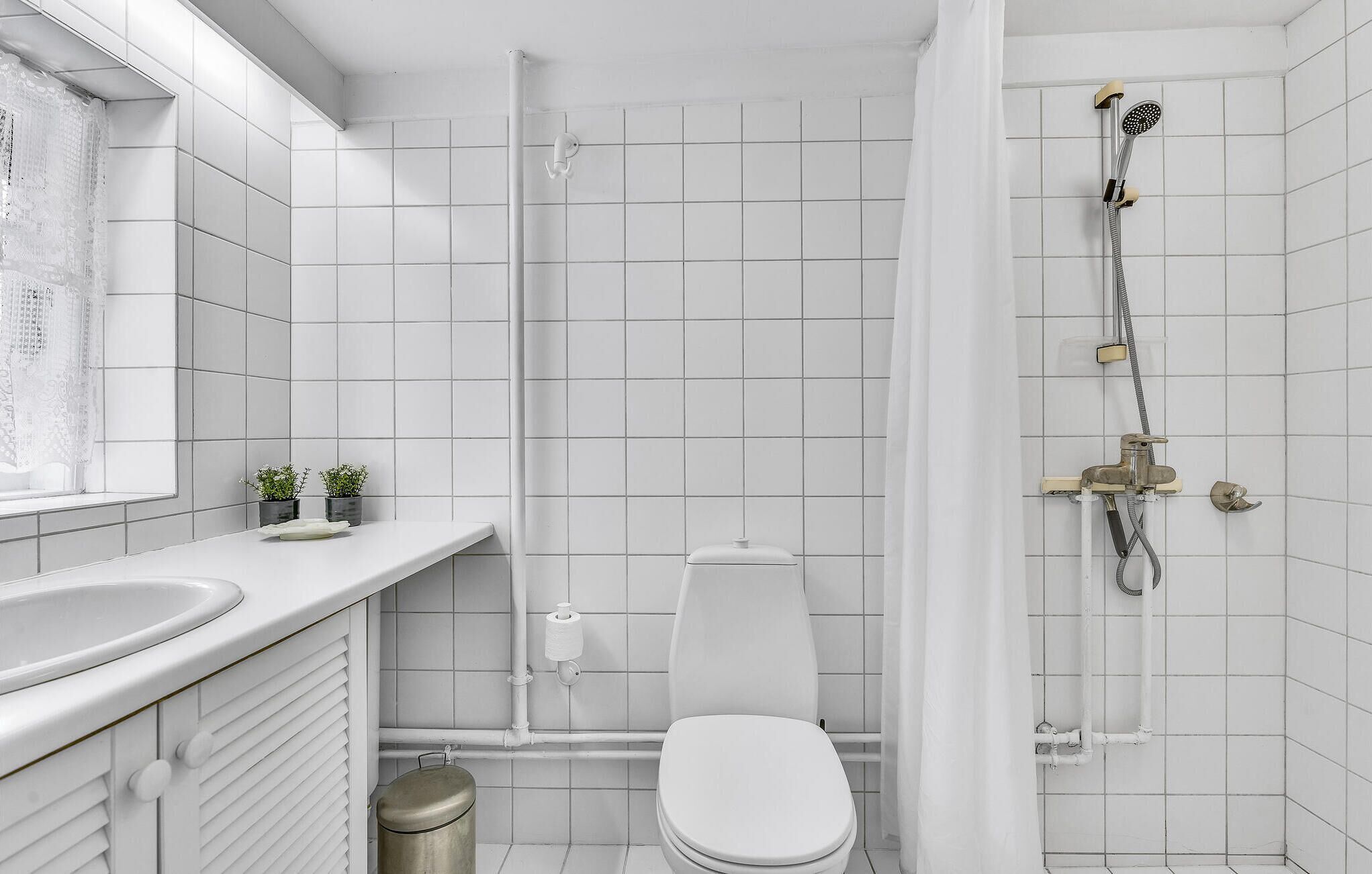 Un baño moderno con inodoro, lavamanos y ducha.