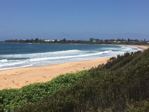 A beach with a sandy shore and waves. - Pearly Shells Beach Cottage- 200m walk to Beach & 500m to shops  - pet friendly (Culburra Beach)