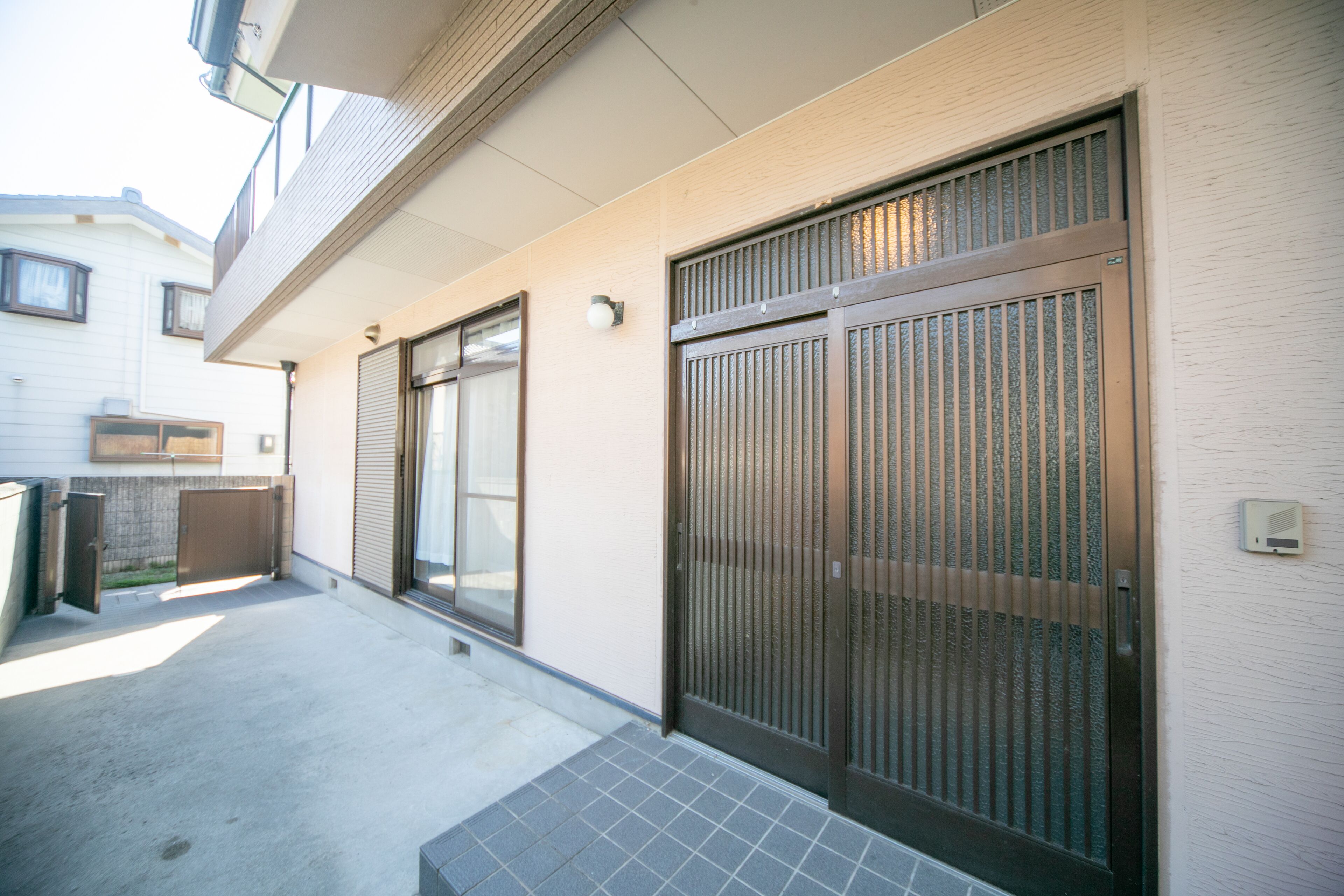 A building with a gated entrance, a sliding glass door, and a metal gate.