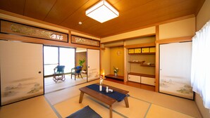 A traditional Japanese room with tatami flooring, a wooden table, and sliding doors. - Awaji Seaside Resort in Shiduki (Awaji)