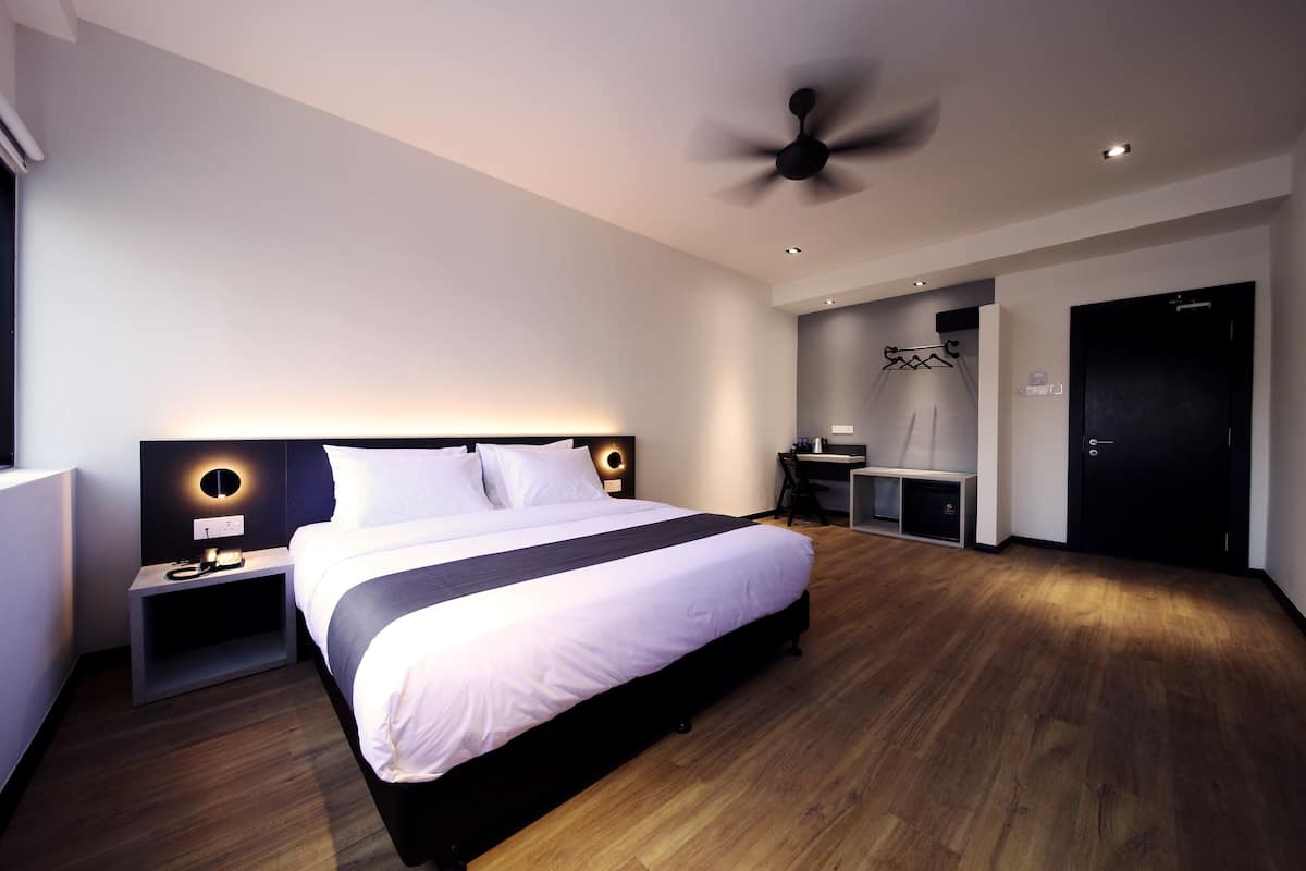 Une chambre d’hôtel moderne, dotée d’un grand lit, d’un bureau et d’une armoire.