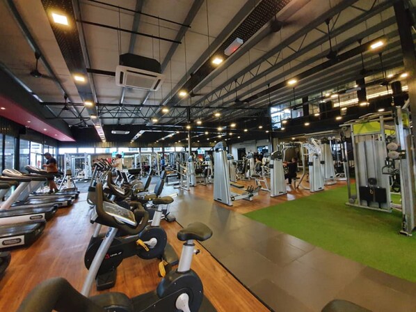 A gym with treadmills, stationary bikes, and weight machines.