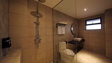 A modern bathroom with a glass-enclosed shower, a toilet, and a sink.