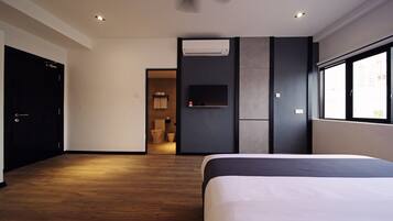 Une chambre d’hôtel moderne dotée d’un grand lit, d’un téléviseur à écran plat, d’un système de climatisation et offrant une vue par la fenêtre.