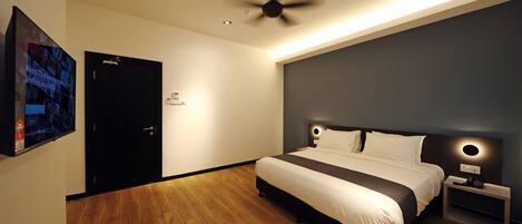 Ein modernes Schlafzimmer mit einem großen Bett, einem Deckenventilator und einem am Wand montierten Fernseher.
