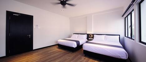 A modern hotel room with two beds, a ceiling fan, and a large window.