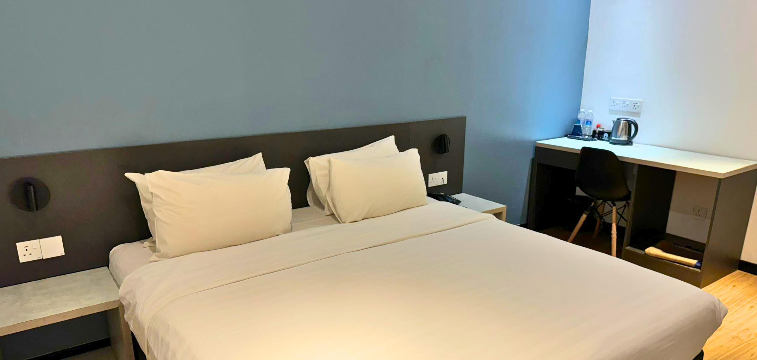 Una habitación de hotel con una cama, un escritorio y una silla.