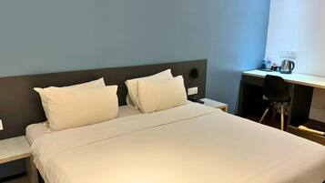 Une chambre d’hôtel avec un lit, un bureau et une chaise.