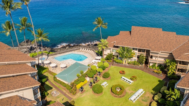 Ein Resort mit Pool, Palmen und Meerblick.