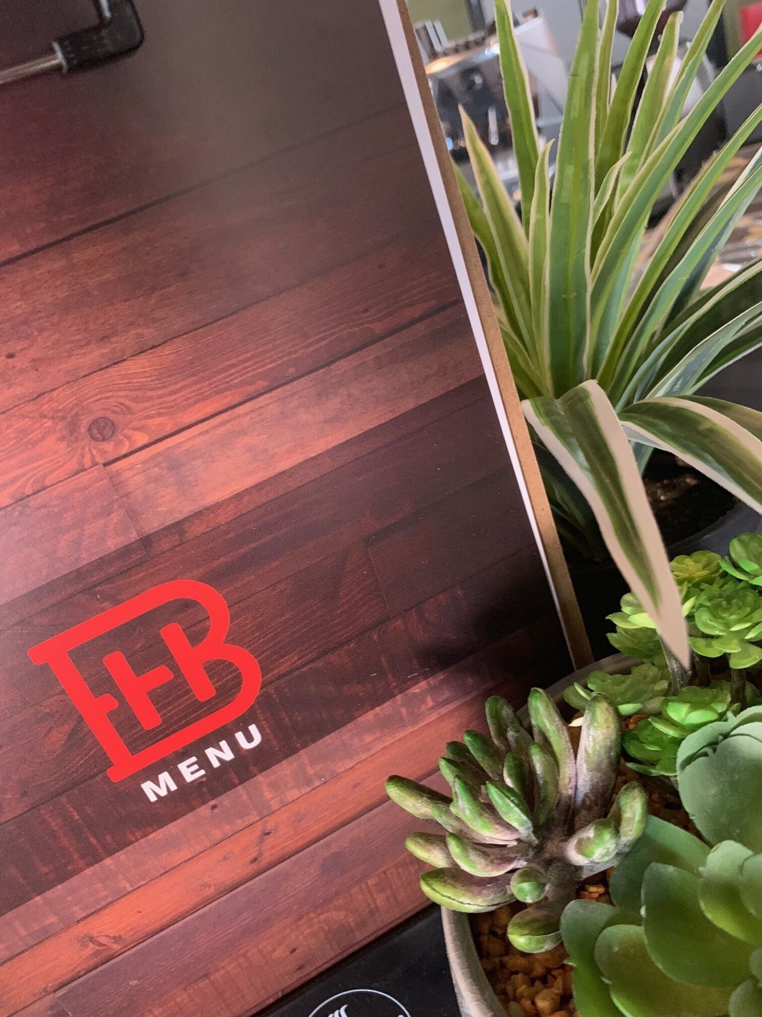Un plancher en bois orné d’un logo et de l’inscription « EB MENU ».