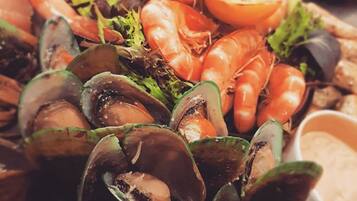 A seafood platter with shrimp, mussels, and a slice of lemon.