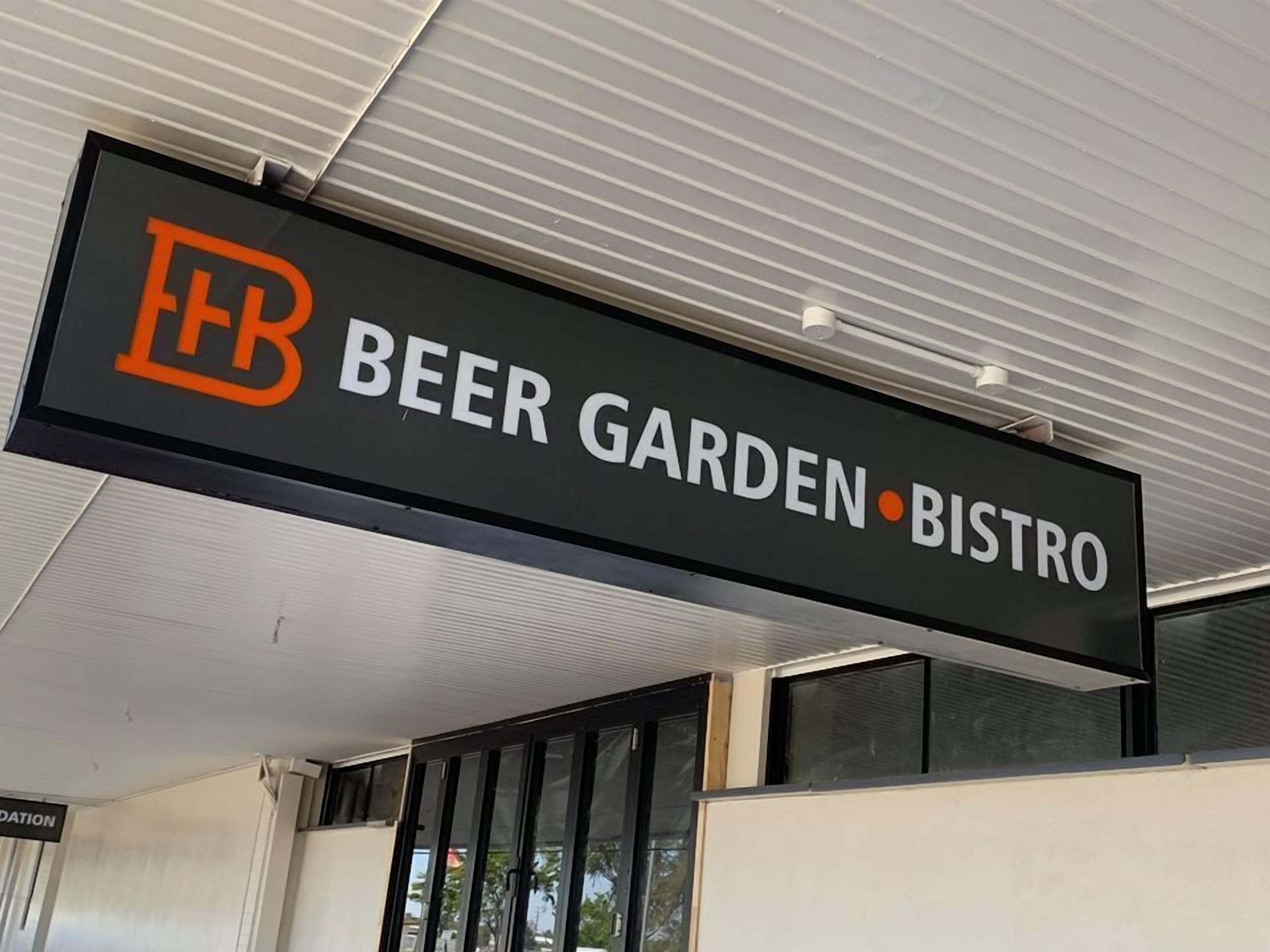A sign for a beer garden and bistro with a logo.