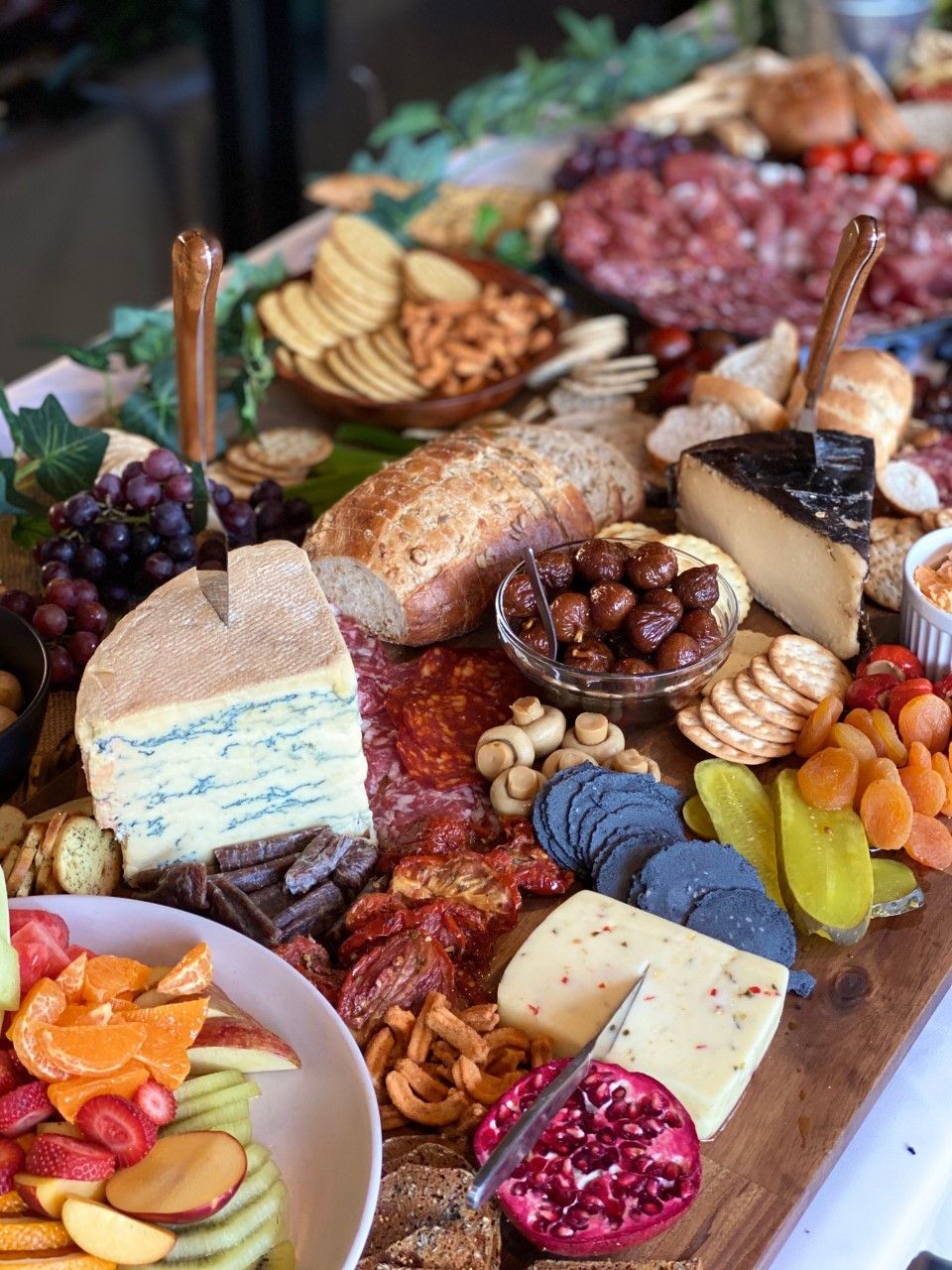 A charcuterie board with various cheeses, cured meats, fruits, and nuts.