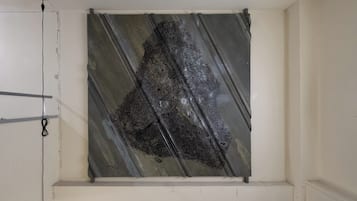 A room with a large, dark, abstract artwork on the wall.
