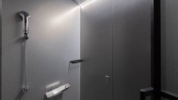 Un baño moderno con ducha, toallero y panel de control.