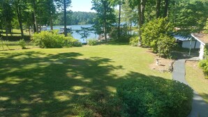 A well-maintained lawn with a pathway leading to a dock by a lake, surrounded by trees and a small gazebo. - Waterfront…Location is everything! (Littleton)