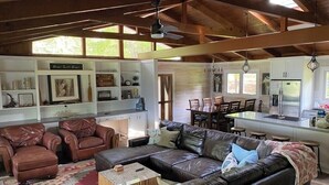 A spacious living area with leather sofas, a coffee table, and a kitchen area with a refrigerator and dining table. - Waterfront…Location is everything! (Littleton)
