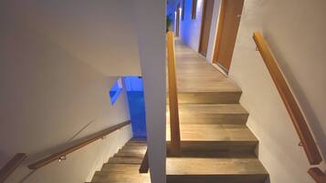 Eine Treppe mit hölzernen Geländern und einer hellen Wand.