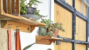 A rustic outdoor kitchen with a sink, wooden shelves, and hanging utensils. - Casa Palo Verde  (Cabo San Lucas)