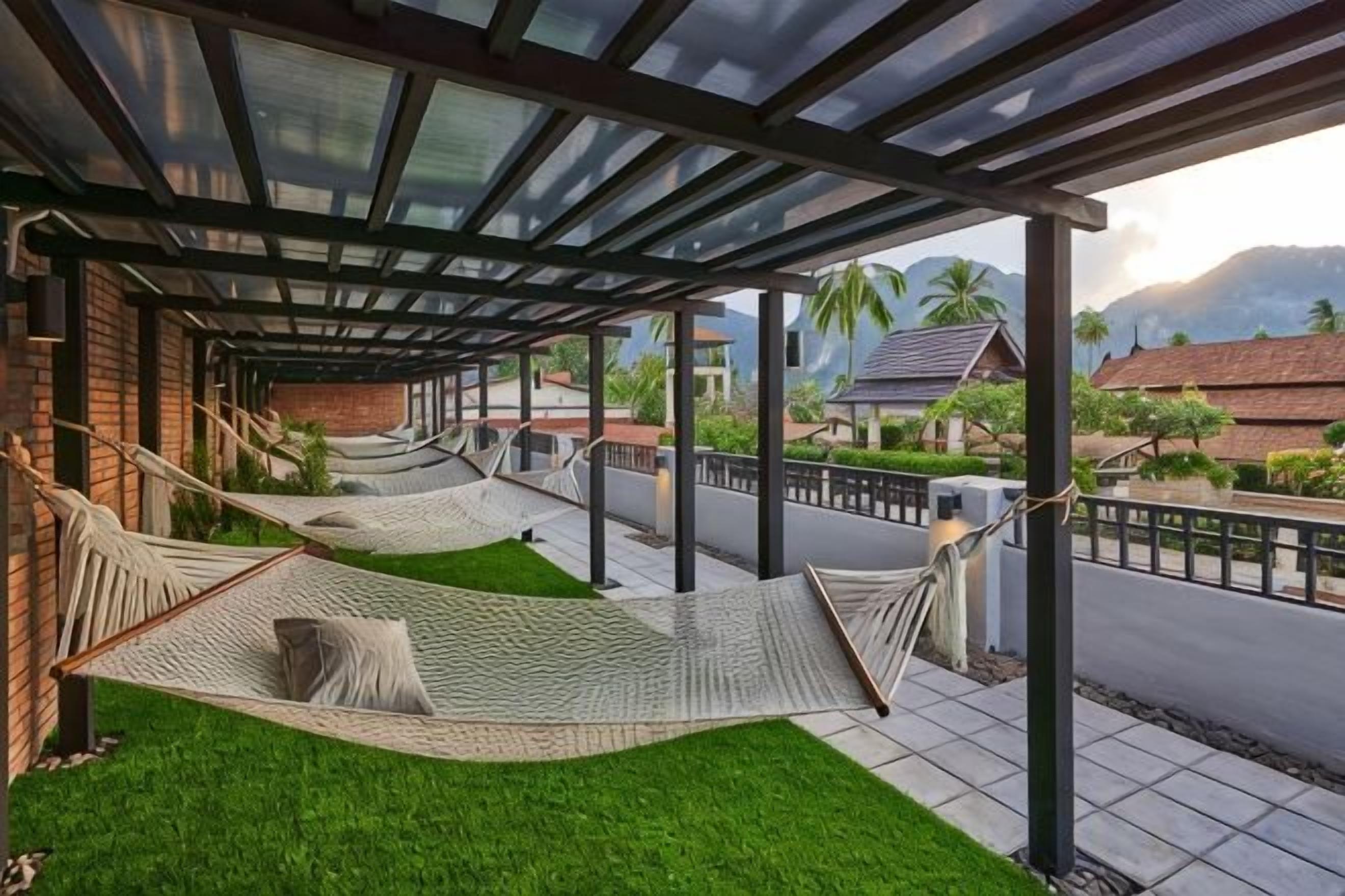 A covered outdoor area with two hammocks and artificial grass.