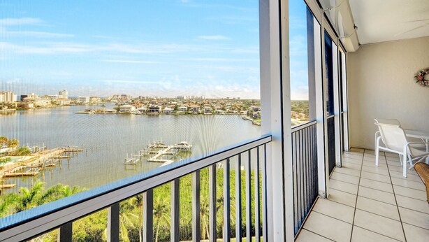A balcony with a view of a marina and cityscape. - Regatta - Enjoy Gulf Views, Walk to the Beach! (Naples)