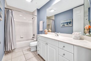 Bathroom features a large shower, bathtub, and toilet, along with a vanity and mirror.