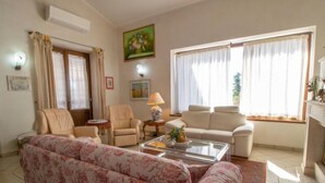 A living room with a sofa set, armchairs, a coffee table, and a fireplace. - La Danza by Interhome (Todi)