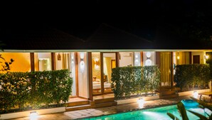 A modern hotel with a swimming pool, well-lit rooms, and a patio area. - Le Candles Resort (Kozhikode)
