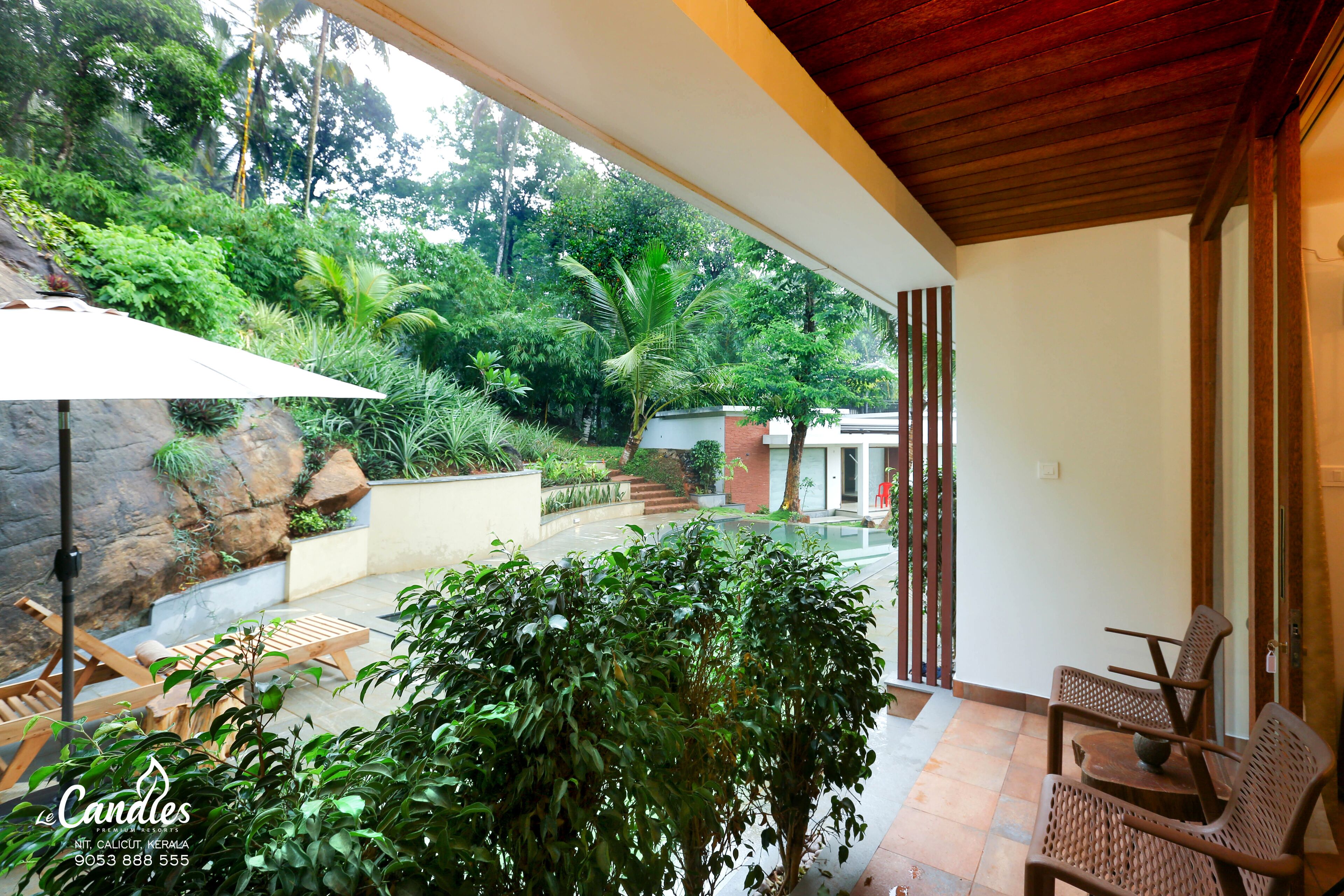 A covered outdoor area with a wooden ceiling, a table with chairs, and a large umbrella.