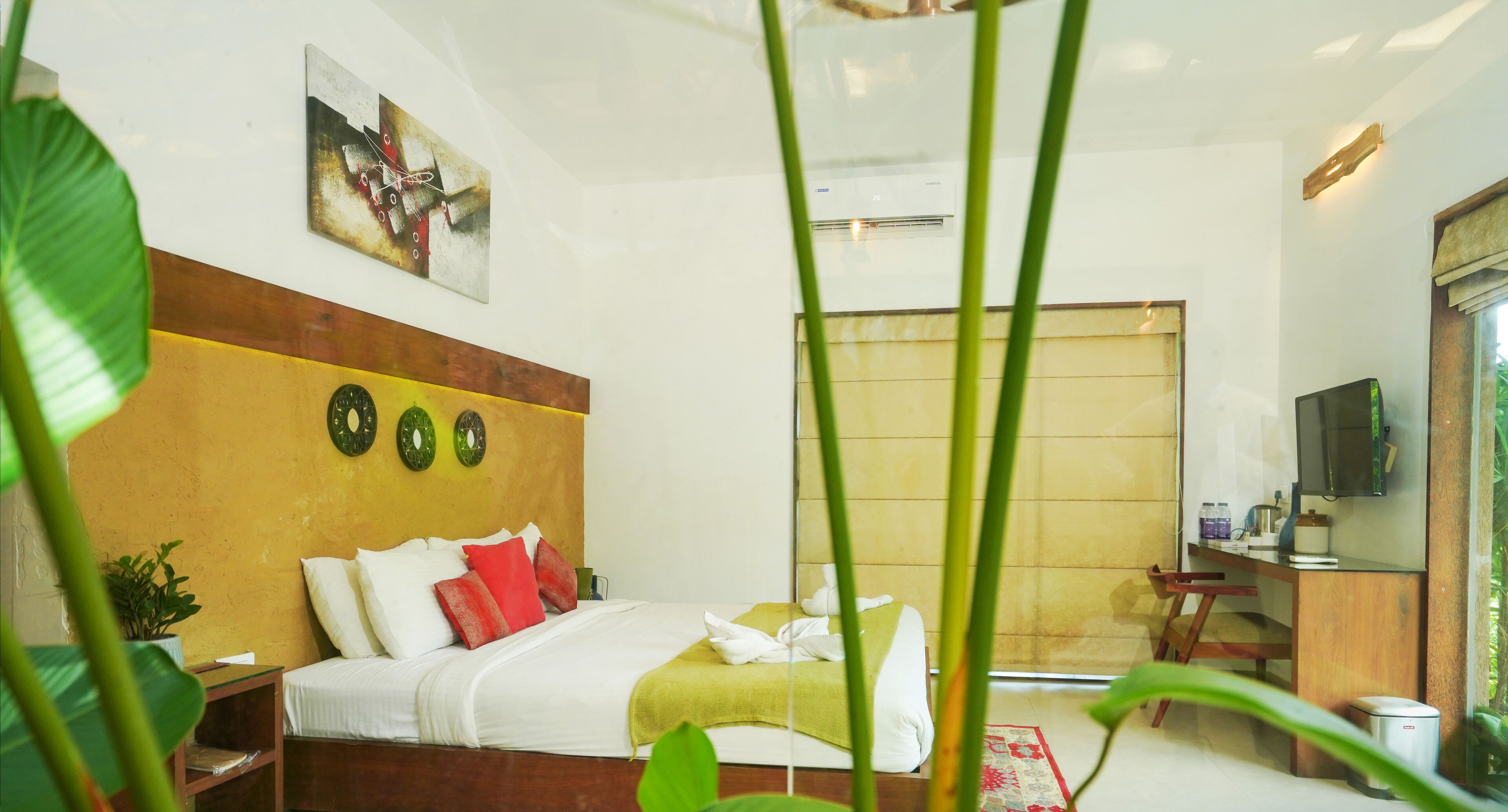 Une chambre d’hôtel avec un lit, une télévision, un bureau et une fenêtre.