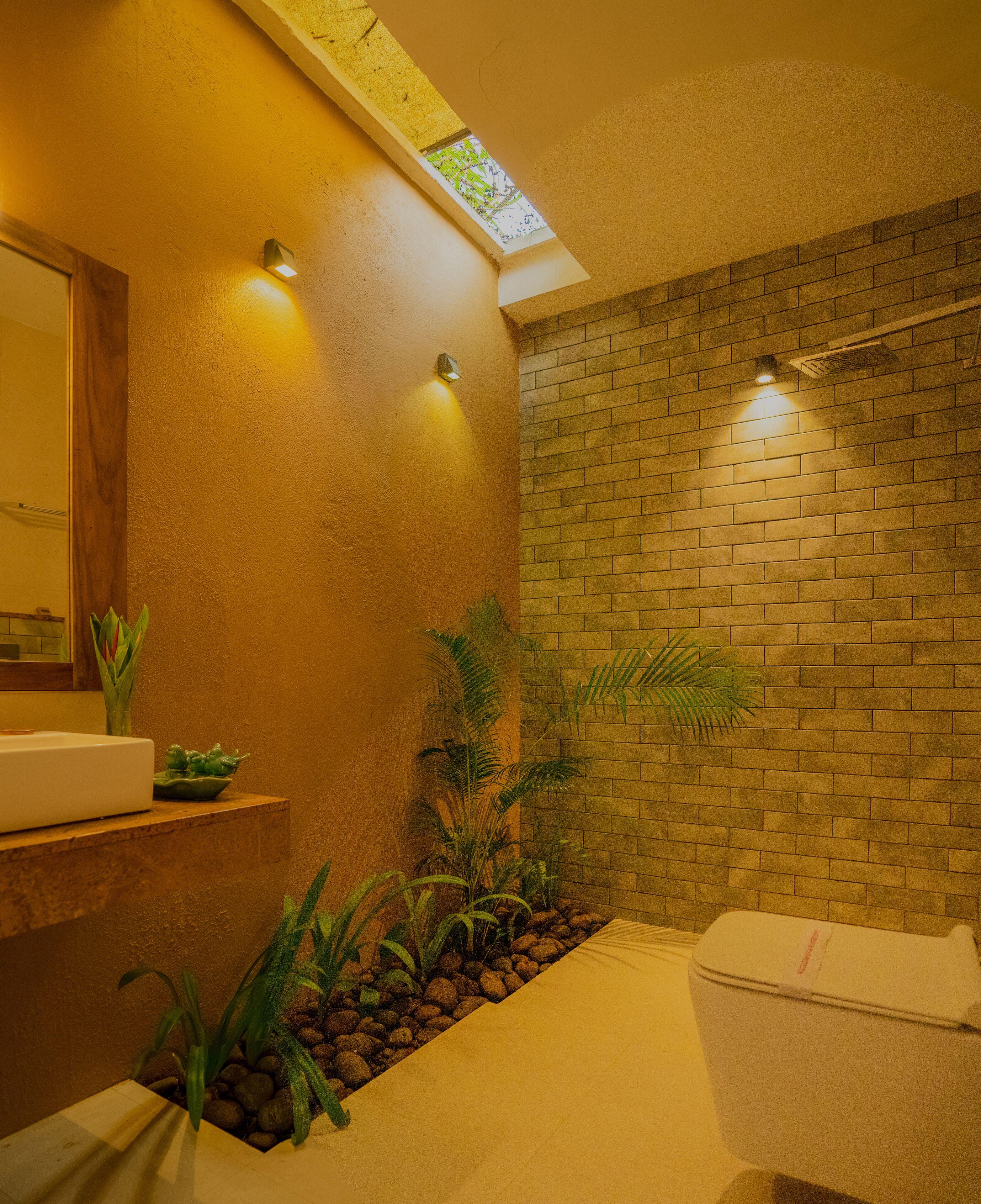 Un baño con pared de ladrillo, tragaluz, lavamanos y retrete.