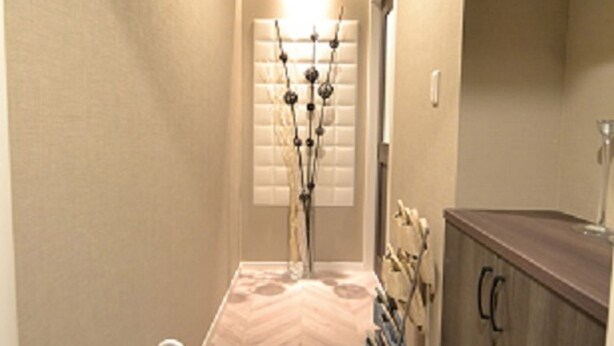 A narrow hallway with a wooden floor, a white floor lamp, and a wooden cabinet with a glass door. - Dekijima Sakura House (Osaka)