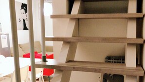 A modern interior with a staircase and a red chair. - Dekijima Sakura House (Osaka)