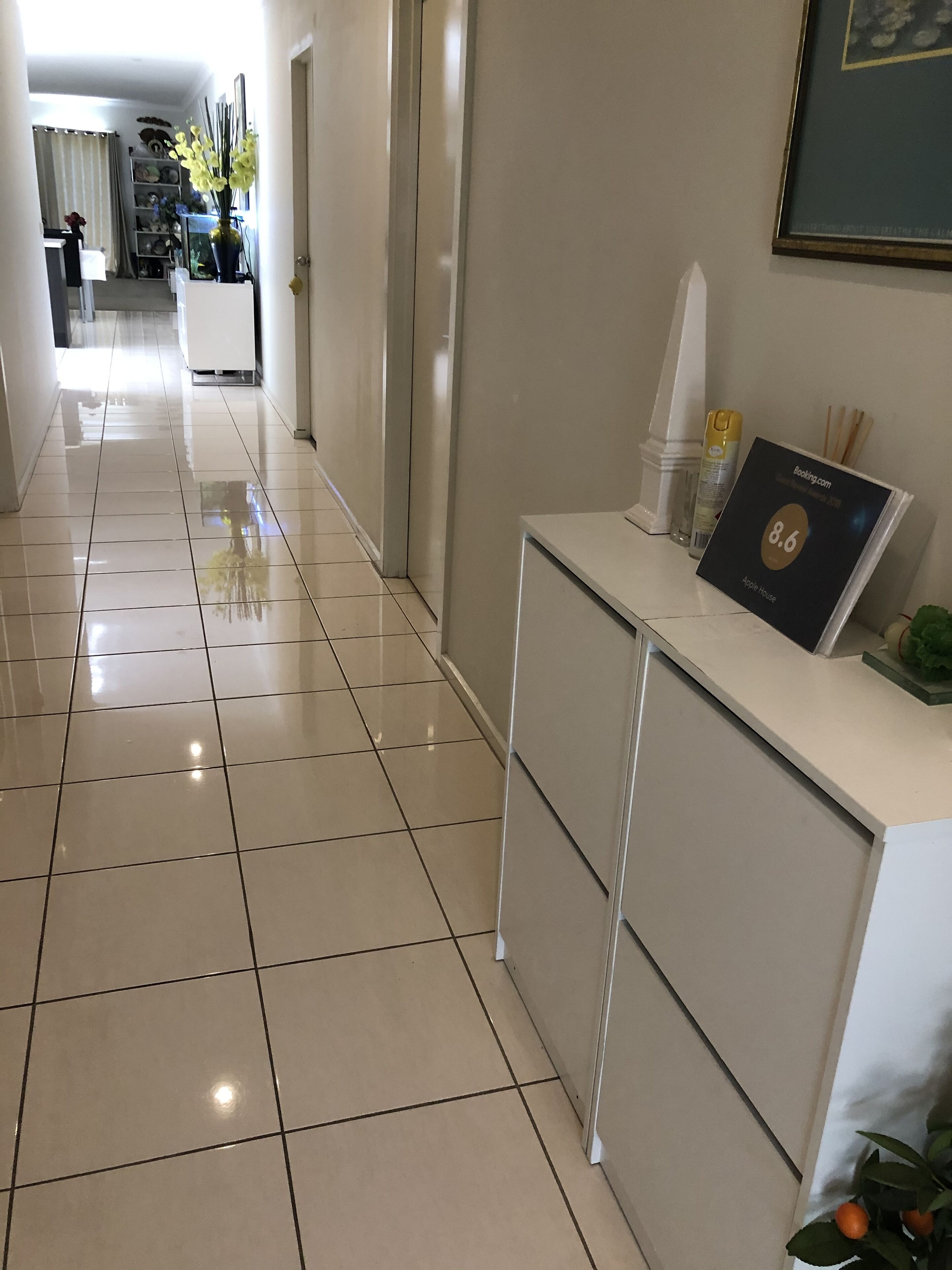 Zona de recepción de un hotel con suelo de baldosas limpias y mostrador de recepción.