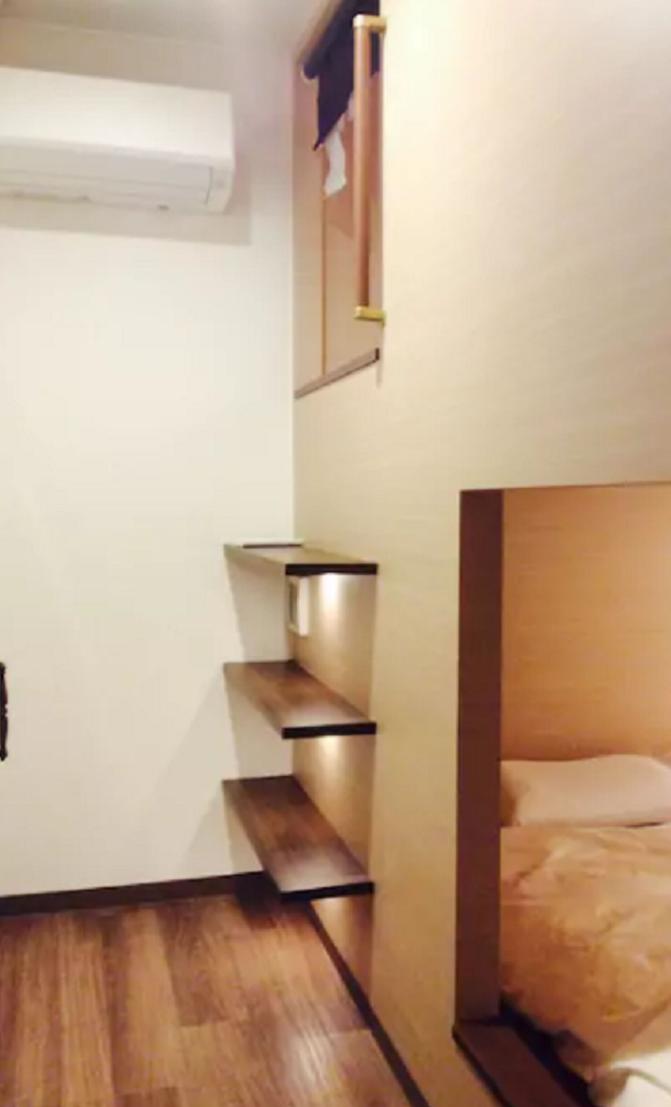 A compact hotel room with a bed, a small desk, and a built-in wardrobe.