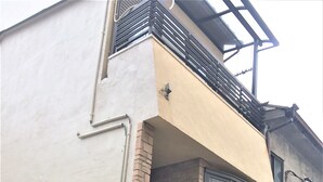 En moderne bygning med en beige facade, en murstensdel og en sort metalport.