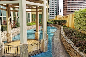 Relax by the serene pool surrounded by lush greenery and a stone wall.