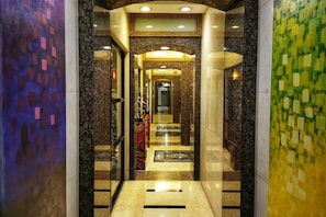 Stunning corridor with a central archway, mosaic tile walls, and glass doors.