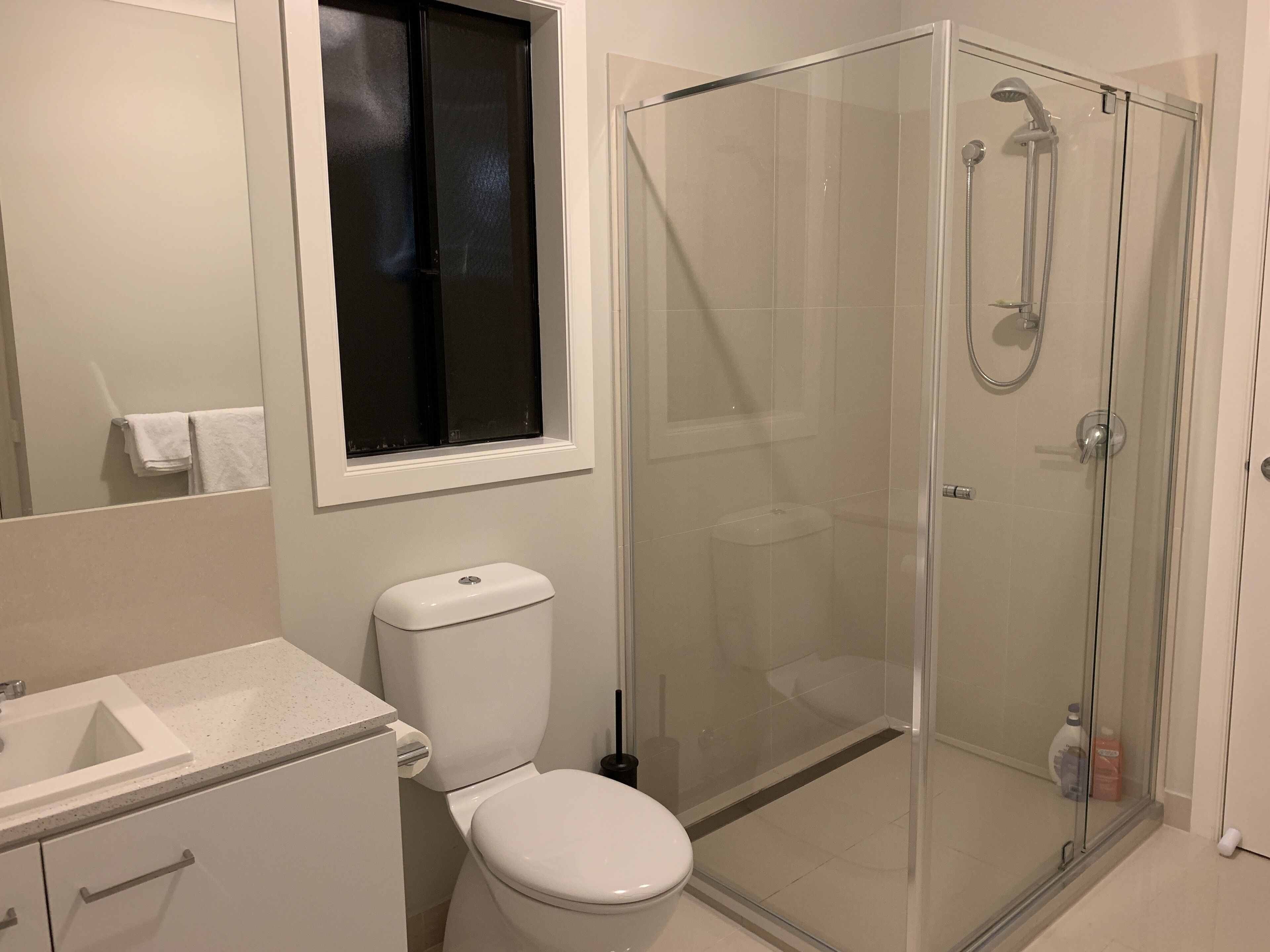 A bathroom with a toilet, sink, and glass-enclosed shower.