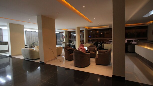 A spacious lobby with modern furniture, a kitchen area, and a bar. - Raoum Inn Serviced Apartments-Majmaa (Al Majmaah)